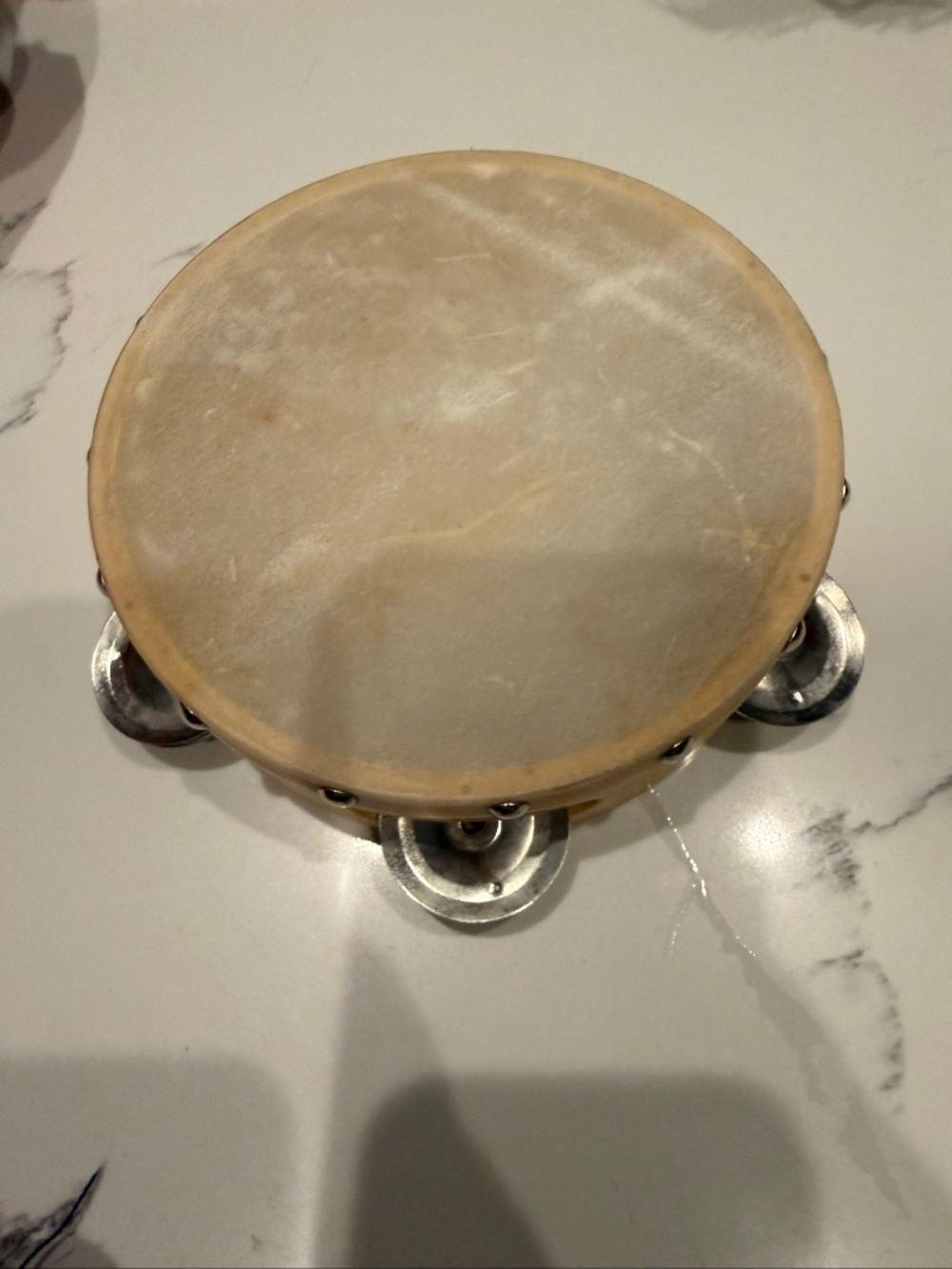 Wood and calfskin tambourine with metal jingles, vintage percussion instrument